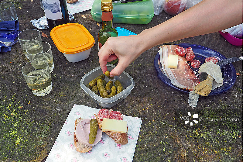 从上方看到的野餐场景，手拿腌制小黄瓜图片素材