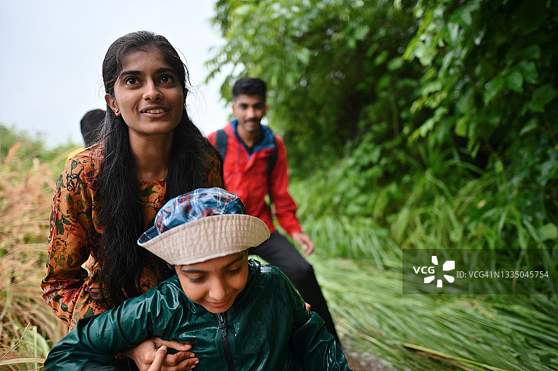 一家人手牵手徒步穿越溪流，其乐融融图片素材