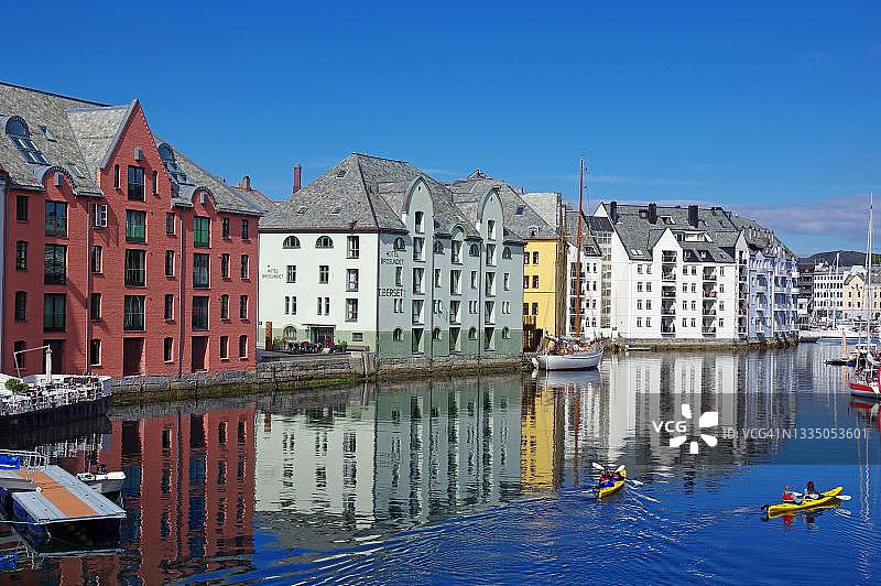 挪威奥勒松港口房屋倒影、皮划艇与新艺术建筑图片素材