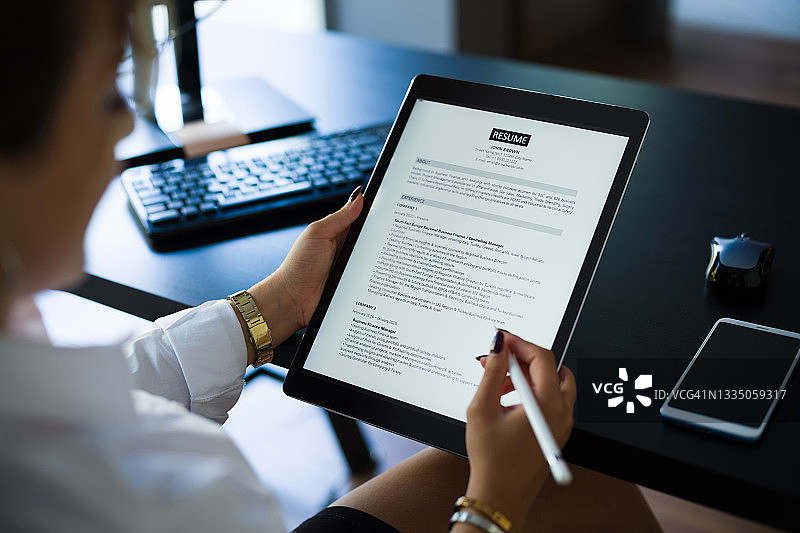女商人用平板电脑阅读简历以招聘合适人选图片素材