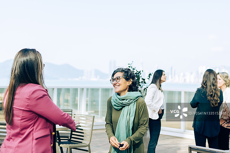 三个女人在交谈，一个女人把手放在口袋里图片素材