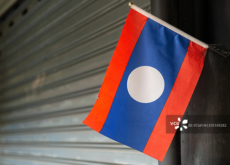 特写：老挝琅勃拉邦纪念品商店前的老挝国旗图片素材