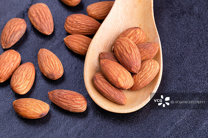石桌背景下的木勺杏仁图片素材