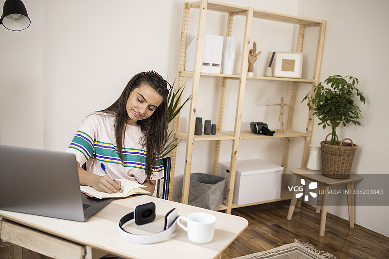 女孩在家中办公室工作和规划工作图片素材