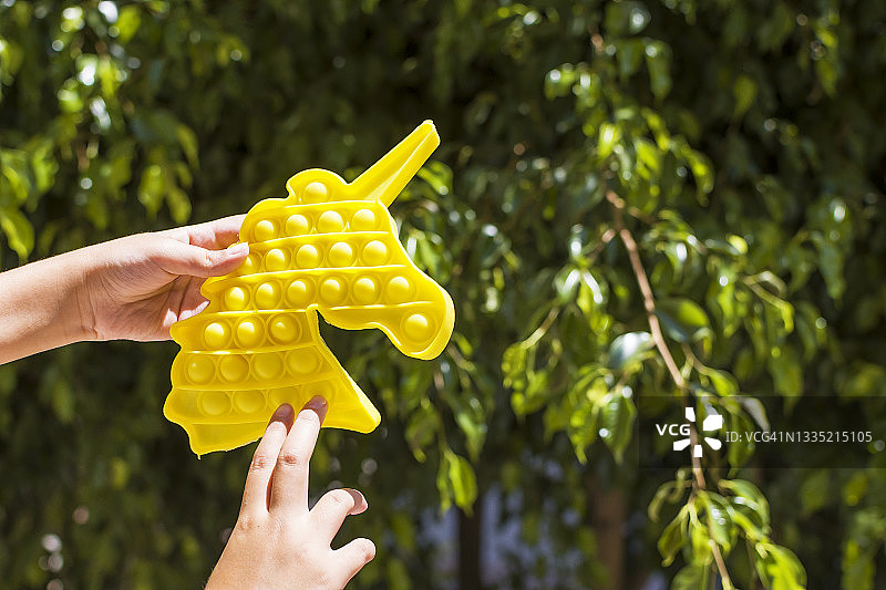 玩黄色按压式解压玩具的漂亮女孩图片素材