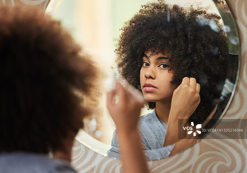 美丽的女人在家照镜子化妆的肖像图片素材