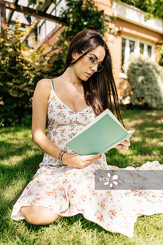 女人在草坪上看书图片素材