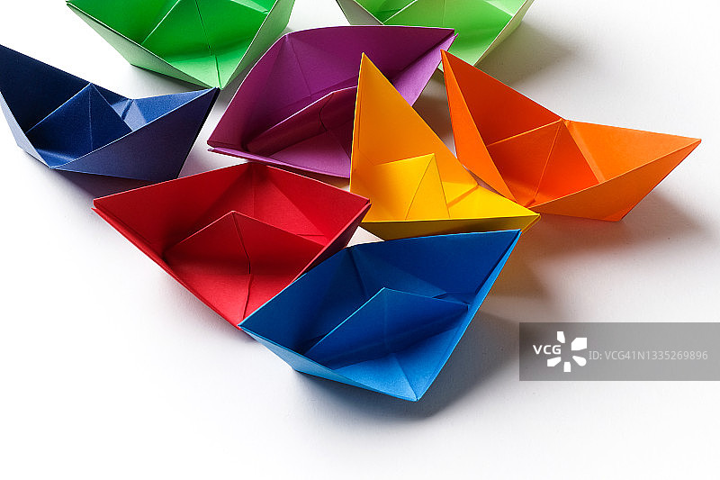 白色背景上手工制作的彩色纸船，商业团队合作概念图片素材