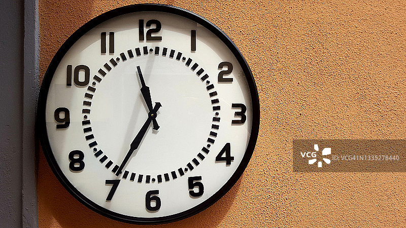 橙色墙面背景上的复古时钟图片素材