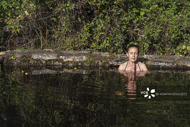 在湖中潜水的中年拉丁妇女图片素材