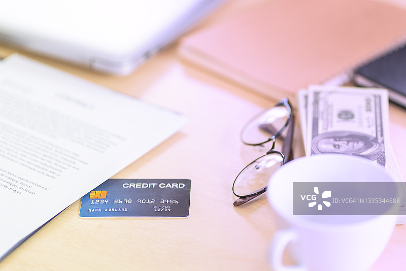 信用卡、美元、眼镜、商务人士办公桌上的咖啡杯图片素材