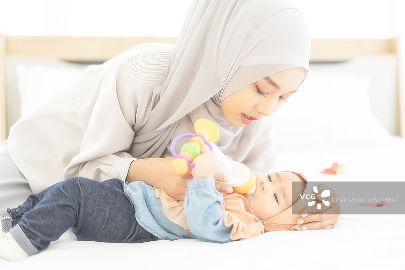 快乐的穆斯林母亲戴着头巾和她的宝宝图片素材