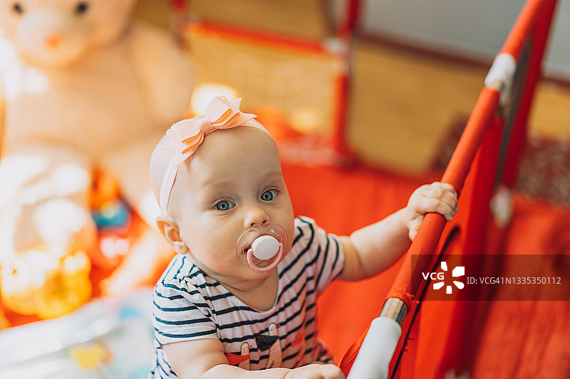 在游戏室里含着奶嘴的婴儿图片素材