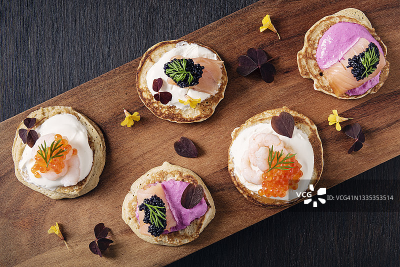 搭配鲜奶油、三文鱼和鱼子酱的俄式薄煎饼图片素材