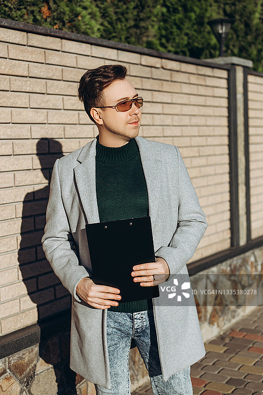 身穿灰色外套的年轻时尚男子图片素材