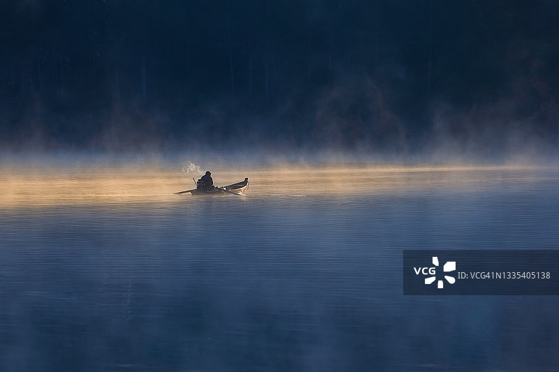 雾气湖面上的孤独渔夫图片素材