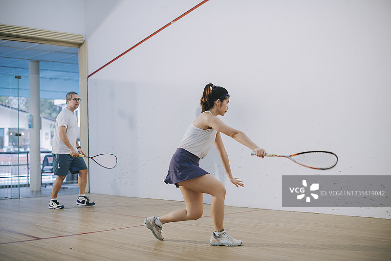 亚洲壁球教练指导女儿练习壁球图片素材