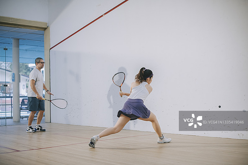 亚洲壁球教练指导女儿练习壁球图片素材