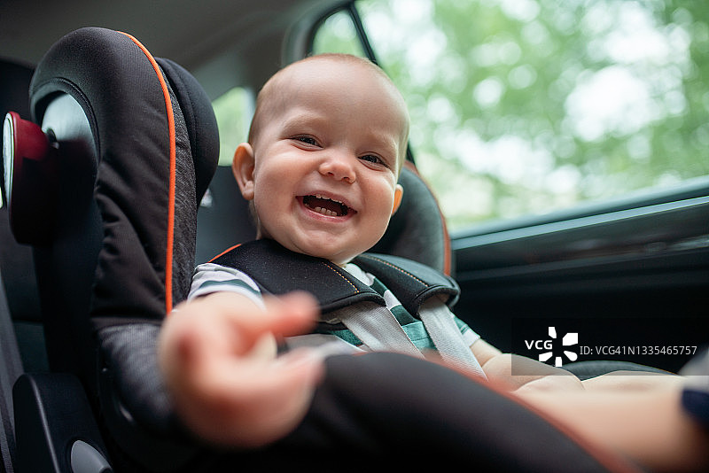 坐在汽车座椅里看着镜头的可爱小宝宝图片素材