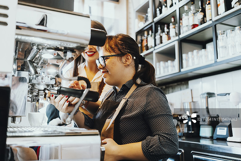 在咖啡馆工作的唐氏综合征年轻女性图片素材