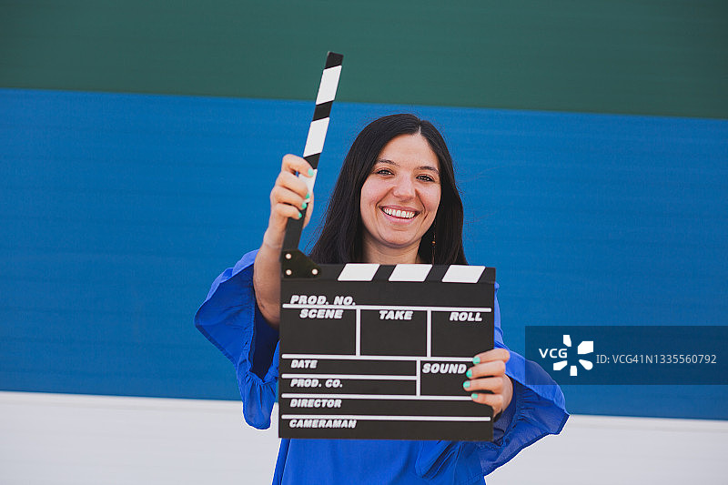 手持电影场记板的年轻女孩图片素材