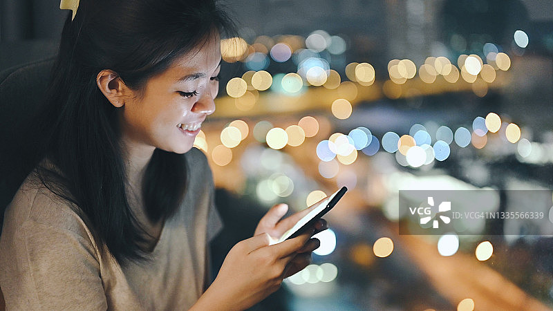 亚洲女大学生在晚上用加密货币在手机上购买电子竞技在线游戏物品图片素材