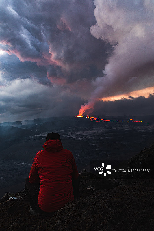 一名男子观看冰岛雷克雅内斯半岛的法格拉达尔火山喷发图片素材