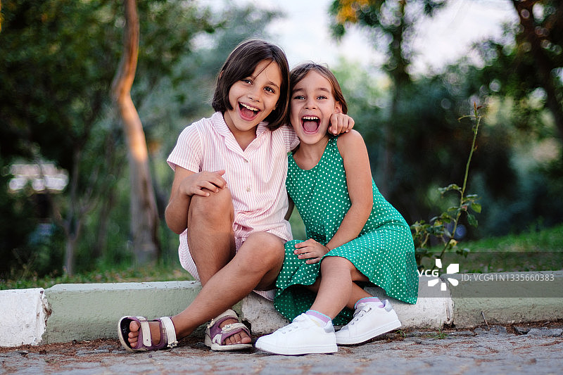 坐在森林里的小姐妹肖像图片素材