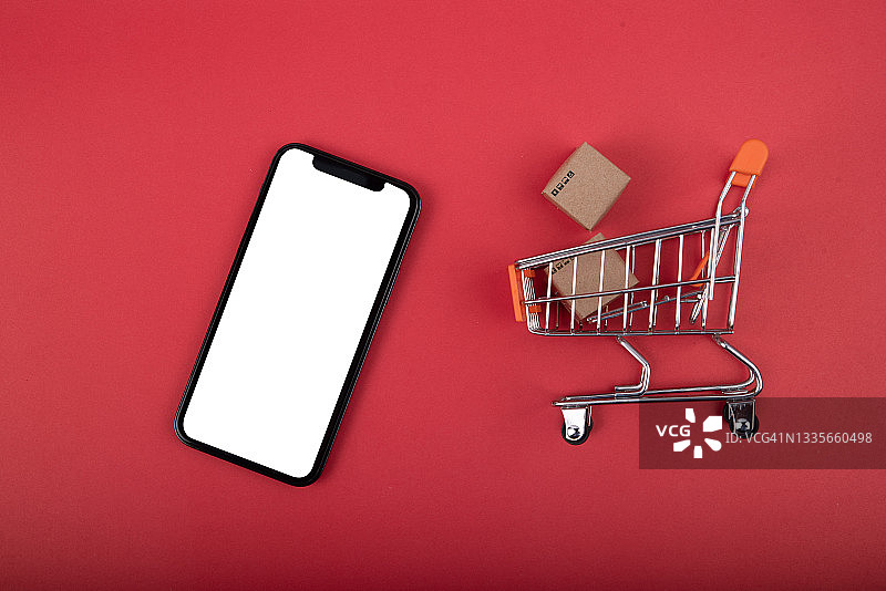 网购与广告概念：购物车、信用卡和智能手机，红色背景图片素材