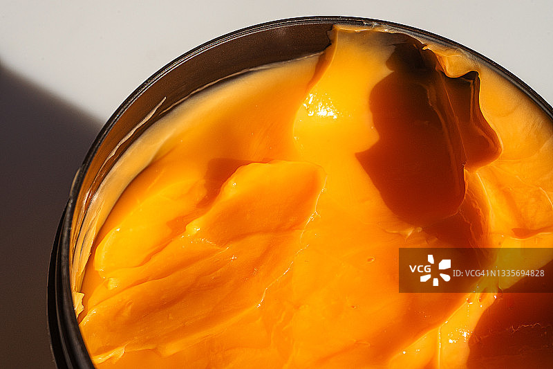 橙色美容产品（面霜或发膜）的光泽质地图片素材
