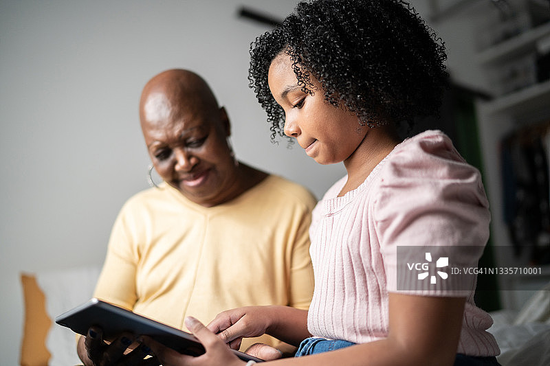 祖母和孙女在家使用平板电脑图片素材