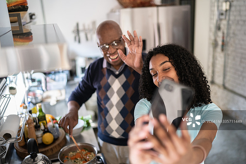 少女在家做饭，与爷爷视频通话图片素材