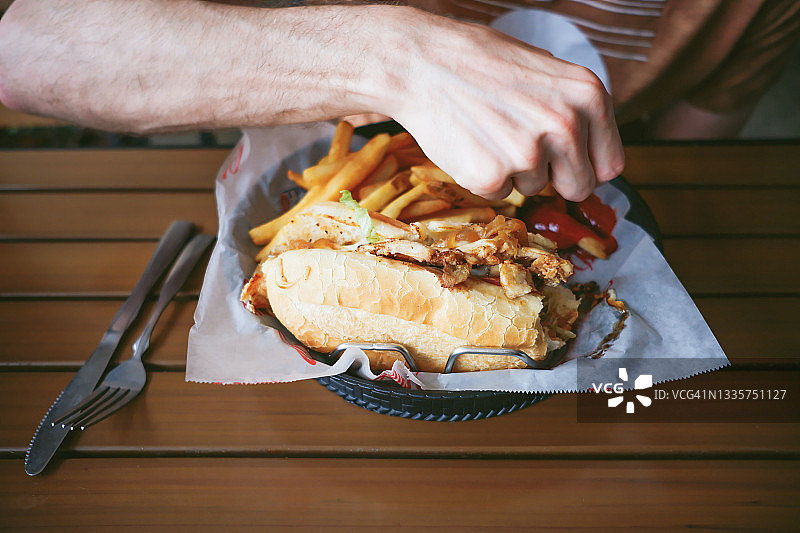 在餐厅吃鸡肉芝士牛排配薯条的男人图片素材