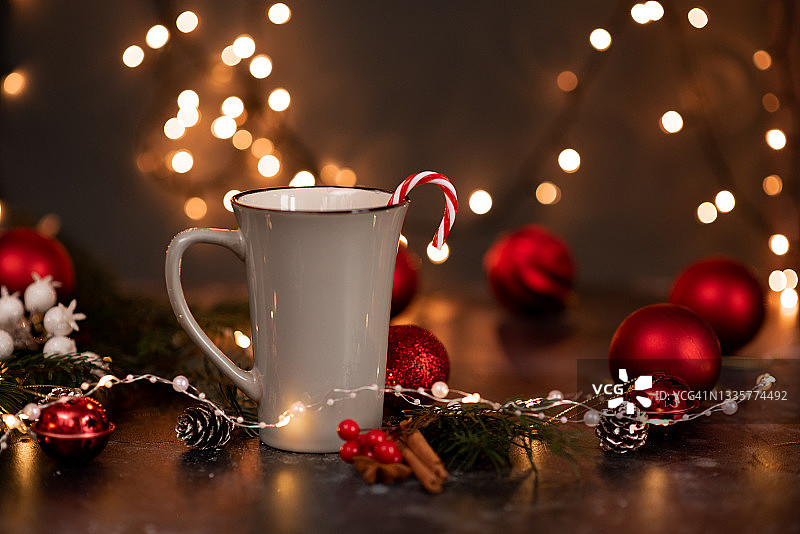 搪瓷杯热可可，搭配心形棉花糖和拐杖糖，乡村背景，散景圣诞灯光图片素材