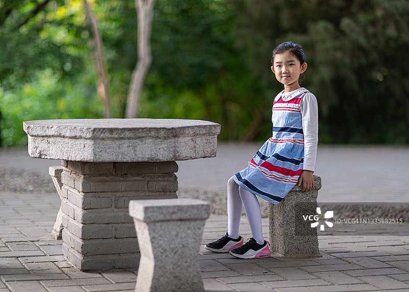 坐在石凳上的小女孩图片素材