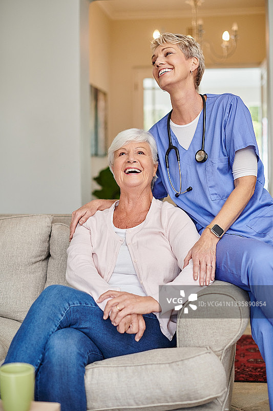 老年妇女与住家保姆坐在沙发上图片素材