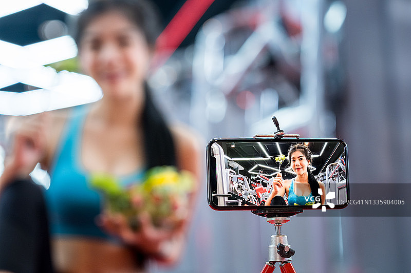 年轻亚洲视频博主与健康食品图片素材