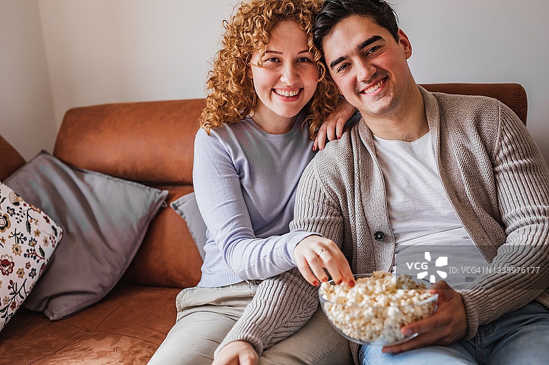 在家吃爆米花的年轻情侣肖像图片素材