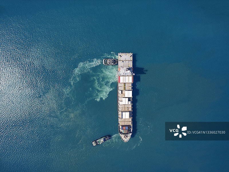 泰国仓库港口中两艘拖船拖拽集装箱货船的航拍俯视图图片素材