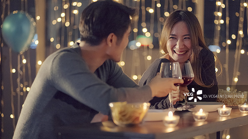 年轻情侣在闪烁灯光下畅饮图片素材