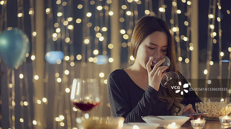女人在灯光照射的餐厅里享用饮品图片素材