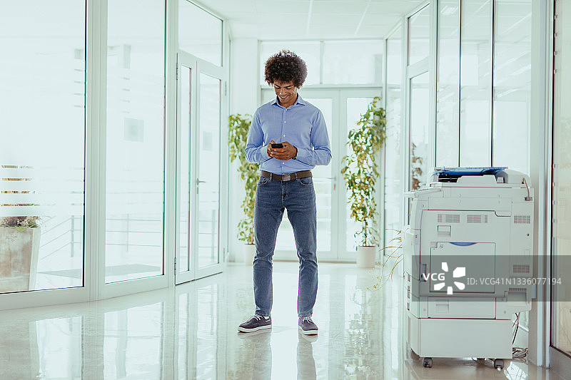 在办公室使用智能手机的非裔美国商人图片素材