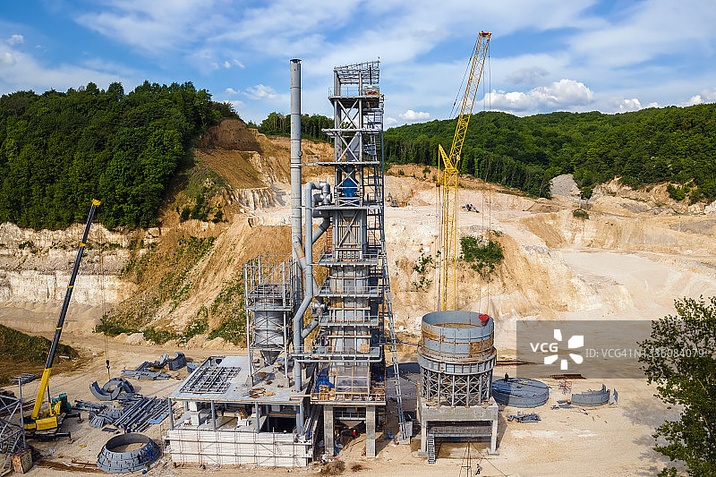 露天矿场水泥厂：挖掘机和自卸车开采建筑砂石图片素材