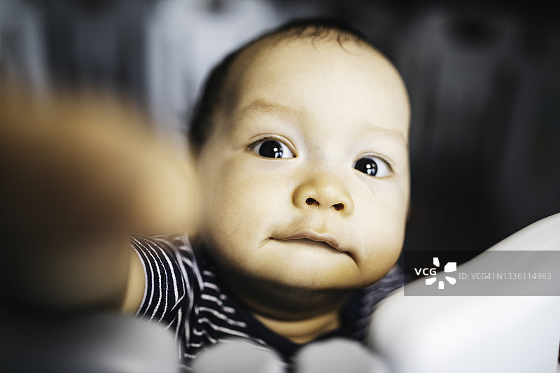 亚洲宝宝站立并扶着床框的肖像图片素材