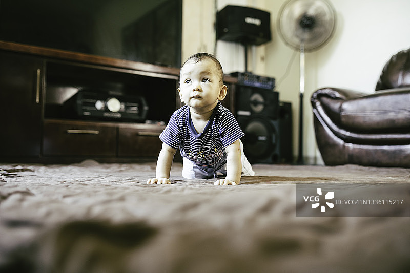 亚洲可爱宝宝在地板上爬行图片素材