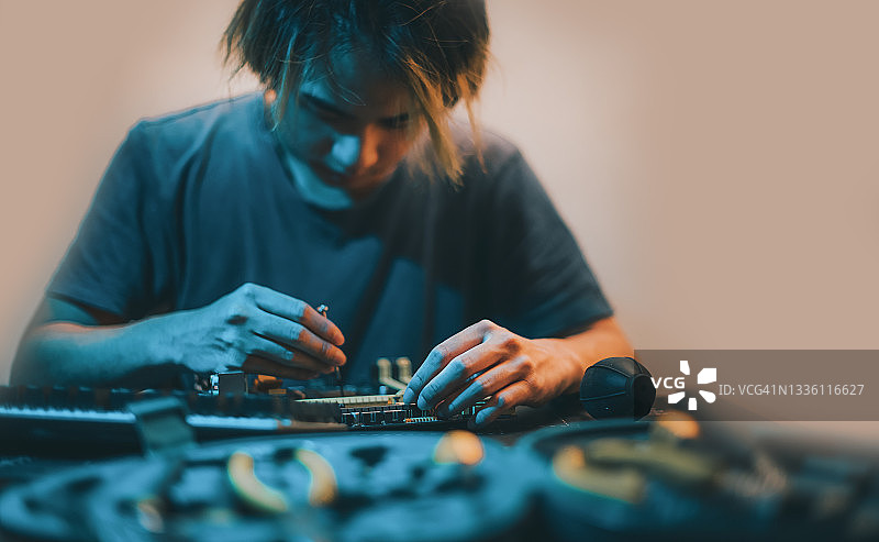 亚洲中国少年在家晚上用工具诊断紧固修理电脑主板图片素材