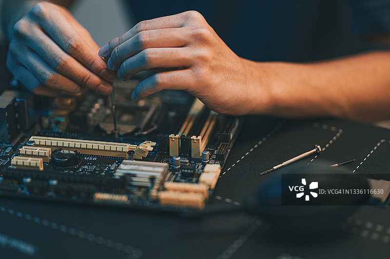 亚洲中国少年在家晚上用工具诊断紧固修理电脑主板图片素材