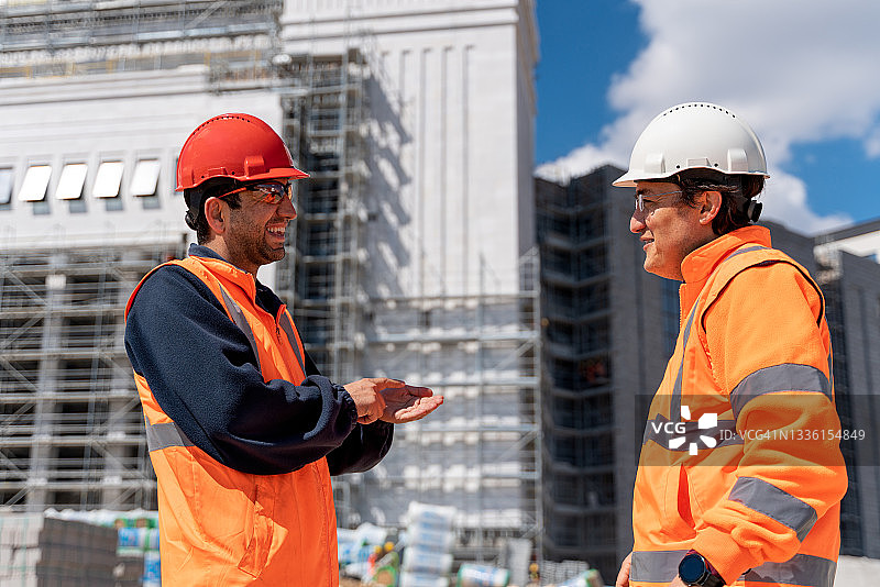 两位工程师在建筑工地交谈图片素材