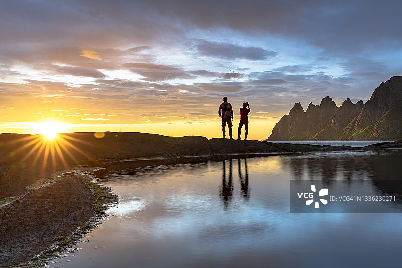 徒步者在挪威用智能手机拍摄午夜阳光图片素材
