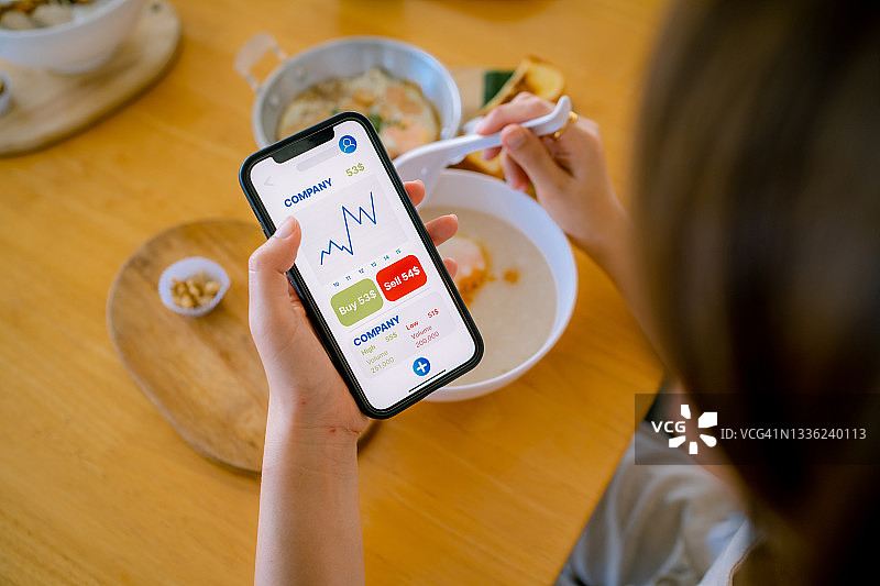 年轻专家分析智能手机上的财务图表图片素材